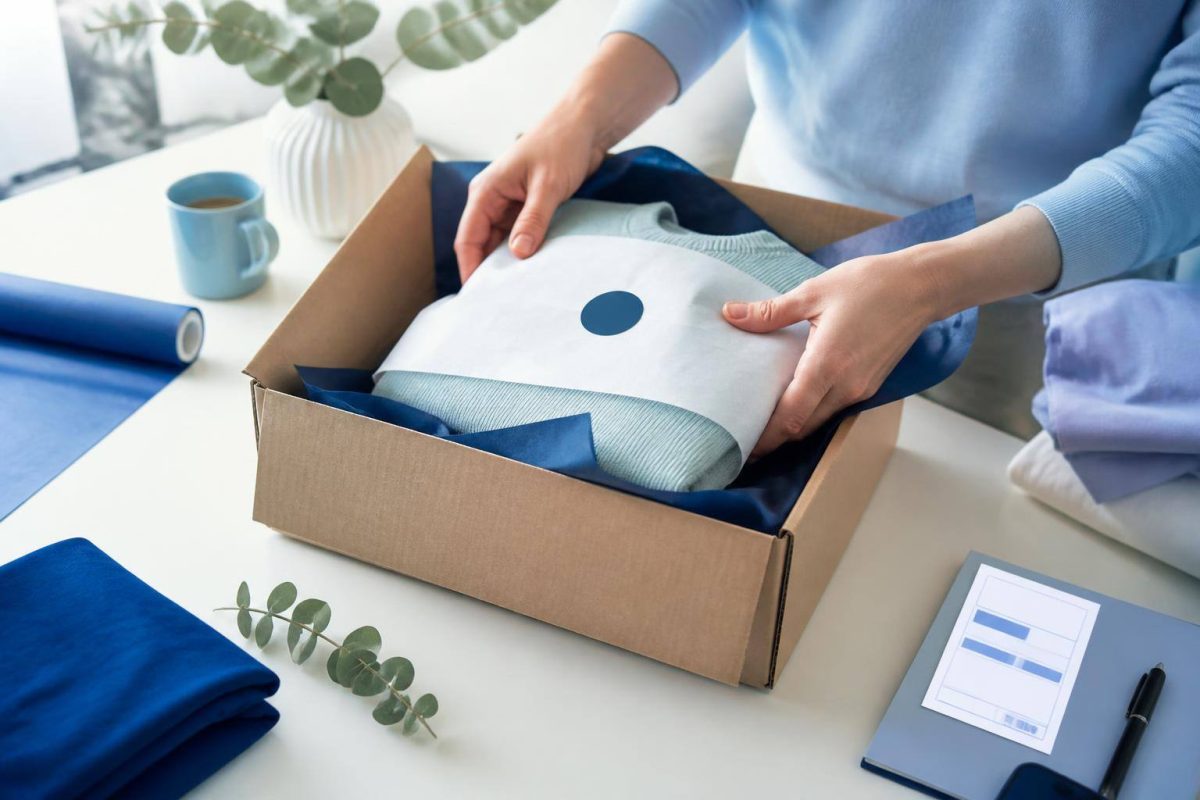Pacote de ecommerce ao lado de caixa aberta, etiqueta de devolução e itens de atendimento ao cliente